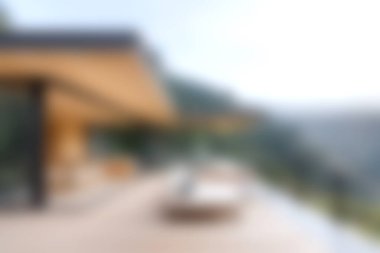 Modern mimari bir tasarımın açık hava güvertesi ile çarpıcı bir temsili, yumuşak ışıkta güzel manzaralı bir dağ manzarası sergiliyor..