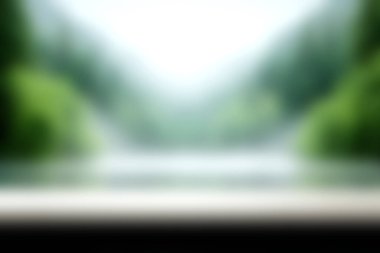 Yumuşak yeşil yapraklar ve sakin bir nehir içeren bulanık doğal bir manzaranın huzurlu bir görüntüsü. Bu görüntü huzuru ve doğanın güzelliğini yakalar..