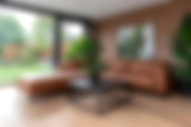 Bu modern oturma odasında kahverengi deri bir kanepe, yemyeşil yeşiller ve rahatlığı teşvik eden davetkar bir atmosfer sergileniyor..