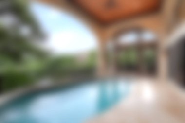 Bu resim, sofistike mimari ve yeşillik tarafından çerçevelenmiş lüks bir kapalı yüzme havuzu sergiliyor ve sakin bir kaçış sağlıyor..