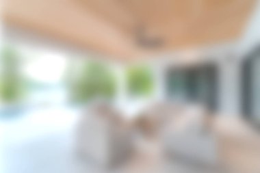 Bu resim, sakin bir atmosferde doğal ışık, rahat mobilyalar ve zarif dekorlarla dolu yumuşak odaklı modern bir yaşam alanını gösteriyor..