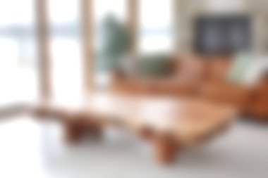 Parlak ve havadar bir oturma odası, kırsal bir kahve masası, geniş pencerelerden geçen doğal ışık ve rahat bir oturma alanı. Modern ev dekorasyonu için mükemmel..