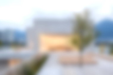 Şehir manzarası içindeki zarif modern mimari yapı, yumuşak odak ve sakin elementler sergiliyor. Tasarım ve yaşam tarzı temaları için ideal.