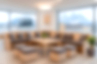 Rahat bir oturma odası, geniş pencereler ve rahatlama ve stili destekleyen sıcak bir atmosfer..