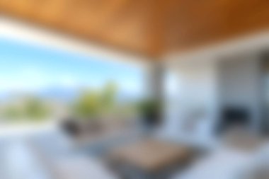 Modern bir oturma odasında geniş pencerelerden zarif mobilyalar ve çarpıcı bir doğa manzarası sergilenerek rahatlatıcı ve davetkar bir atmosfer yaratılır..