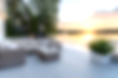 Günbatımında, modern mobilyalar ve yemyeşil, rahatlama ve rahatlama için mükemmel, sakin bir açık hava yaşam alanının tadını çıkarın..