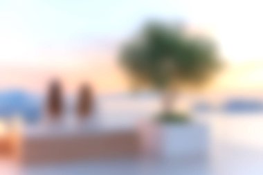 Modern tasarım elementleri ve sakin bir atmosferle çevrili güzel bir günbatımının keyfini çıkaran iki siluetli figürlü sakin bir teras sahnesi..