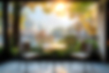 Büyük cam bir pencerenin yanında rahat sandalyelerin bulunduğu rahat bir iç mekan. Sıcak güneş ışığıyla yıkanmış ve yeşilliklerle çevrili huzurlu bir doğa manzarası sunuyor..