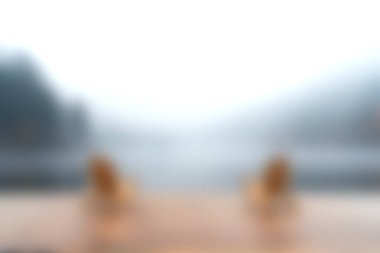 Sise buğulanmış sakin bir göl sahnesinde suya bakan iki siluetli figür görülüyor. Yumuşak renkler ve sakin bir atmosfer doğada huzurlu bir an yaratır..