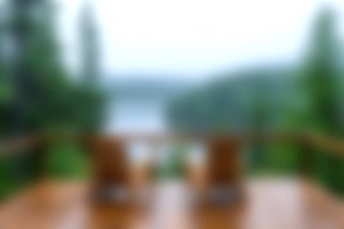 Bu görüntü ahşap bir güverteden büyüleyici bir görüntü yakalar, sisli bir göl ve çevreleyen yeşillikler. Rahatlama ve doğa aktarımı için ideal..