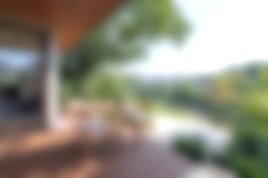 Bu resim, modern mimari ve doğa manzaralı sakin bir açık hava manzarası sergiliyor. Yumuşak odak, rahatlamak için mükemmel bir ortam yaratıyor..