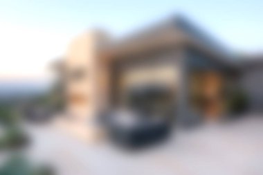 Zarif tasarım elementleri ve panoramik günbatımı manzaralı, manzarada zarafet ve rahatlığı çağrıştıran modern lüks bir villanın rahatlatıcı görüntüsü..