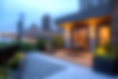 Alacakaranlıkta yemyeşil bitkiler ve güzel şehir manzaralı, rahatlama ve sosyal toplantılar için mükemmel, rahat bir şehir terasının atmosferinin tadını çıkar..