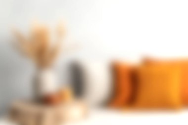 Sıcak bir oturma odası sahnesi. Canlı turuncu minderleri ve zarif kurumuş çiçekleri var. Sıcaklık ve rahatlık saçıyor. Şık bir ev için mükemmel bir ilham kaynağı..