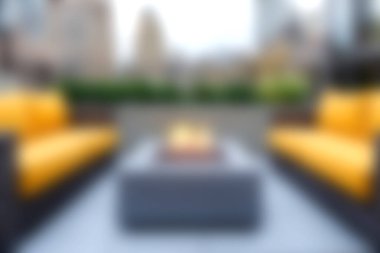 Şehirde rahatlama ve sosyal etkinlikler için mükemmel, modern sarı koltuklu ve şık bir şöminesi olan rahat bir şehir çatı salonu deneyin..