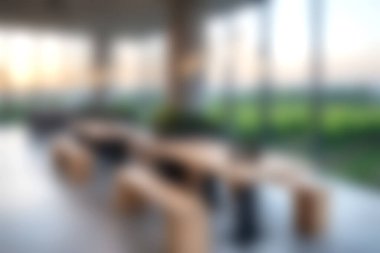 Minimalist ahşap mobilyalar ve doğal ışığı ve yemyeşil manzarayı davet eden geniş pencereler içeren sofistike bir iç mekan..