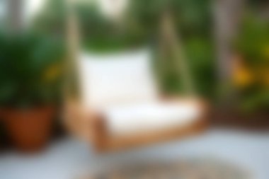 Bu resim, canlı yeşilliklerle çevrili huzurlu bir bahçeye kurulmuş rahat bir salıncak sandalyesini gösteriyor. Rahatlamak ve eğlenmek için mükemmel bir dinlenme yeri..