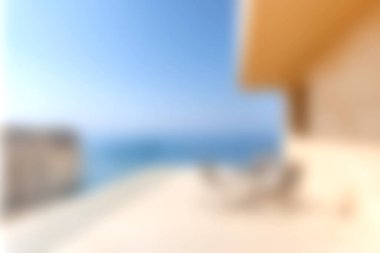 Modern bir balkonda nefes kesici okyanus manzaralı saf rahatlama deneyimi. Açık mavi gökyüzü sakin sularla buluşur, huzurlu bir kaçış yaratır..