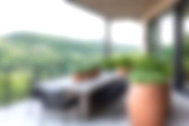 Bu resim canlı yeşillik ve manzaralı tepe arkaplanı olan rahat bir açık hava oturma alanını gösteriyor. Doğada rahatlama ve keyif için mükemmel bir yer..