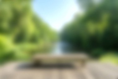 Sakin bir nehre bakan, güneşli bir günde canlı yeşillik ve canlı doğa ile çevrili ahşap bir bankın huzurlu bir görüntüsü. Rahatlamak için mükemmel..