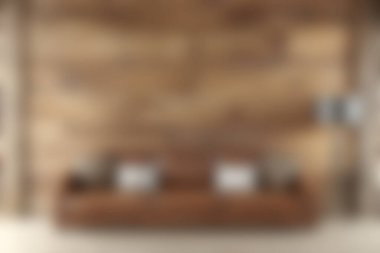 Beyaz yastıklı rahat ahşap bir kanepe kırsal ahşap duvarlı modern bir yaşam alanında davetkar bir atmosfer yaratıyor..