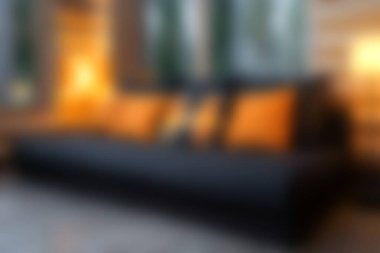 Sıcak yastıklar ve davetkar ışıklandırmalarla süslenmiş şık bir kanepenin olduğu rahat, modern bir oturma odası keşfedin. Rahatlama ve estetik için mükemmel..