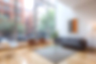 Bu modern oturma odası geniş pencereli, yeşil bitkili ve şık mobilyalı, rahat bir şehir atmosferi yaratan geniş bir yerleşime sahip..