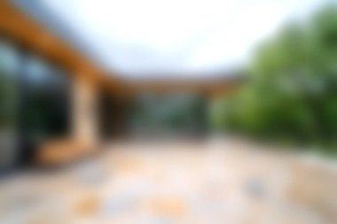 Bu resim rahatlama ve konfor için tasarlanmış, gösterişli mimari, doğal elementler ve davetkar bir ambiyans içeren modern bir açık hava yaşam alanını gösteriyor..