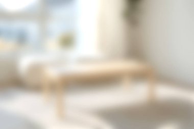 Doğal ışıkla aydınlatılmış, rahatlama ve şık dekorasyon için mükemmel ahşap bir masa içeren parlak ve rahat bir minimalist oturma odası..