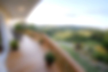 Bulanık bir görüntü serin bir balkon sergiliyor yemyeşil ve uzak tepeler parlak bir gökyüzü altında, rahatlamak ve doğaya kaçmak için mükemmel.