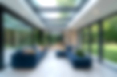 Serinlemek için tasarlanmış göz kamaştırıcı bir modern cam oda, parlak doğal ışık ve dışarıda yemyeşil bir manzara. Çağdaş iç mekanlar için ideal.