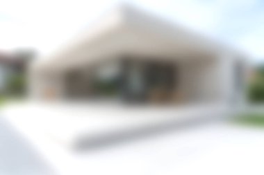 Bu resim, temiz çizgileri ve açık alanları ön plana çıkaran, sakin bir yaşam tarzını teşvik eden bulanık bir dış cephe içeren modern bir mimari tasarım sergiliyor..