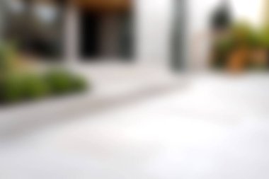 Bu yumuşak odaklı resim, yeşil alanlarla çevrili modern bir evin girişini gösteriyor. Temiz çizgiler ve davetkar bir atmosfer vurgulanıyor..