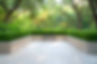 Yumuşak odaklı yemyeşil peyzaj manzarası, bulanık ağaçlar ve bitkilerle birlikte doğanın sükunetini sergiliyor ve sakin bir açık hava yaratıyor..