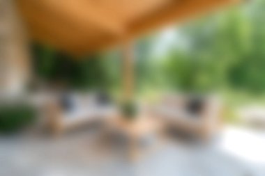 Bu resim, yemyeşil bir arkaplan arasında ahşap mobilyaların yer aldığı sakin bir bahçe avlusunu tasvir ediyor. Rahatlama ve sosyal toplantılar için mükemmel..