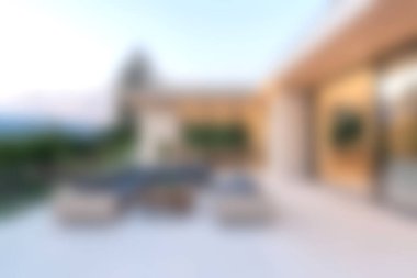 Rahatlamak için tasarlanmış, şık şezlonglar ve güzel bir gün batımı manzarası olan lüks ve konforlu bir avlu..