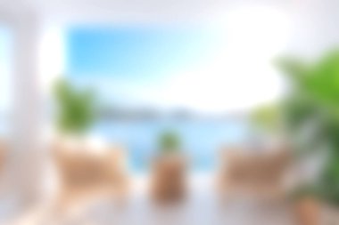 Bu resim, rahat mobilyalar, canlı bitkiler ve rahatlamayı artıran davetkar bir deniz manzaralı parlak ve modern bir kıyı yaşam alanı sergiliyor..