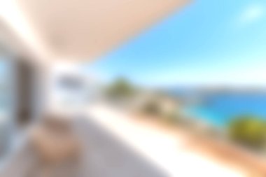 Modern bir balkon sahnesinde parlak mavi gökyüzünün altında nefes kesici bir okyanus manzarası var. Lüks bir apartman atmosferinde rahatlama ve sükuneti davet ediyor..