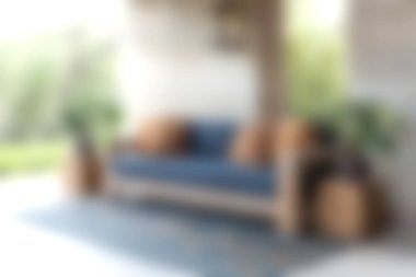 Yastıklarla bezenmiş, yemyeşil bitkilerle çevrili, rahatlamak ve keyif almak için mükemmel, mavi bir kanepe içeren parlak ve davetkar bir yaşam alanı..