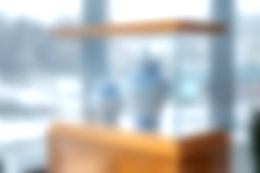 Bu resim, modern tasarım ve sükuneti somutlaştıran ahşap bir rafta zarif vazolar sergileyen bulanık bir iç görüntü alanına sahiptir..