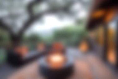 Sıcak ışıklandırmanın, rahat oturmanın ve bereketli doğal çevrenin bulunduğu rahat bir açık hava salonu, rahatlama ve sosyal etkinlikler için mükemmel..