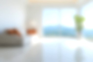 Bu resim, modern mobilyaların, manzaralı bir manzaranın olduğu geniş pencerelerin ve yeşilliğin dokunuşunun yer aldığı parlak ve havadar bir oturma odasını betimliyor..