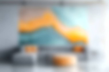 Modern bir oturma odasında, zarif mobilyaları ve davetkar uzay düzenlemeleri ile sıcak bir atmosfer vurgulanarak, yumuşak renklerle canlı ve soyut duvar sanatı sergileniyor..