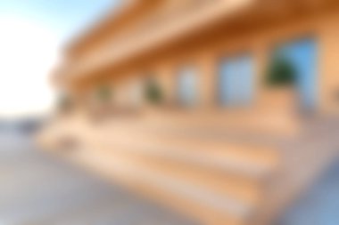 Bu görüntü, zarif basamakları ve saksısı olan, sükunet ve yeni tasarımı çağrıştıran modern bir binanın bulanık görüntüsünü yakalıyor..