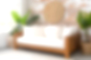 Yeşillik ve yumuşak ışığın ortasında minimalist bir kanepenin sergilendiği rahat bir oturma odası sahnesi, rahatlama ve modern tasarım estetiği için mükemmel..