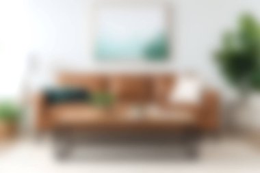 Modern, rahat bir oturma odasında, yeşil bitki ve soyut sanatla eşleştirilmiş şık kahverengi bir kanepe sergilenerek, herkes için davetkar ve rahatlatıcı bir atmosfer yaratılıyor..