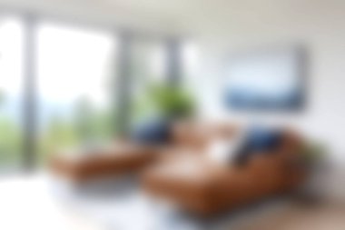 Parlak ve davetkar modern oturma odası lüks bir deri kanepe, geniş pencereler ve huzurlu doğal manzarayla rahatlamak için ideal bir yer yaratıyor..