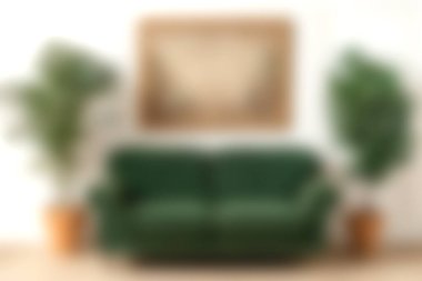 Bu davet odası, kapalı alan bitkileri ve minimalist bir sanat eseriyle tamamlanmış lüks yeşil bir kanepeye sahip. Modern dekor estetiği için mükemmel..