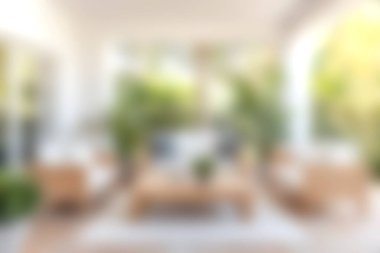 Bu resim, yemyeşil ve doğal ışık ile çevrili modern ahşap mobilyaların sergilendiği, rahatlamak için tasarlanmış rahat bir açık hava oturma alanını içeriyor..