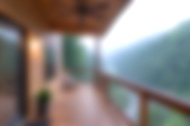 Bu görüntü, sisli bir dağ manzarasına bakan bir balkondan, huzur ve sükunet hissi uyandıran bulanık bir görüntü yakalıyor..